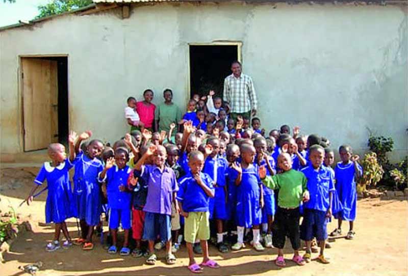 School children and staff in Africa stood outside