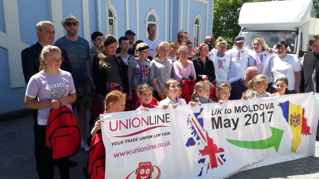 Group of volunteers and school children holding a CWUHA banner