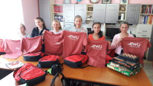 School children holding CWU shirts